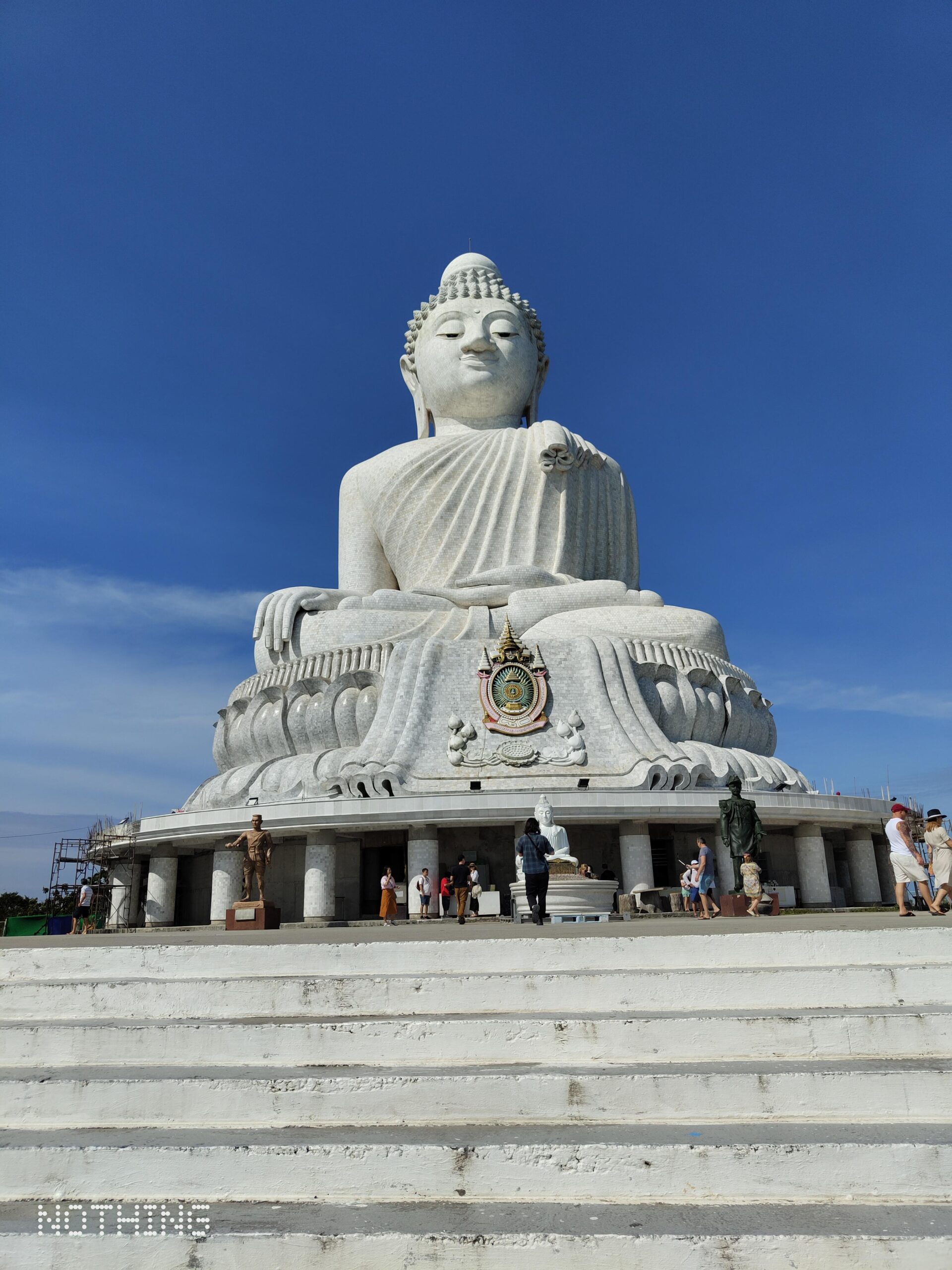 Big Buddha Phuket statue viewed from the base, with visitors on the steps